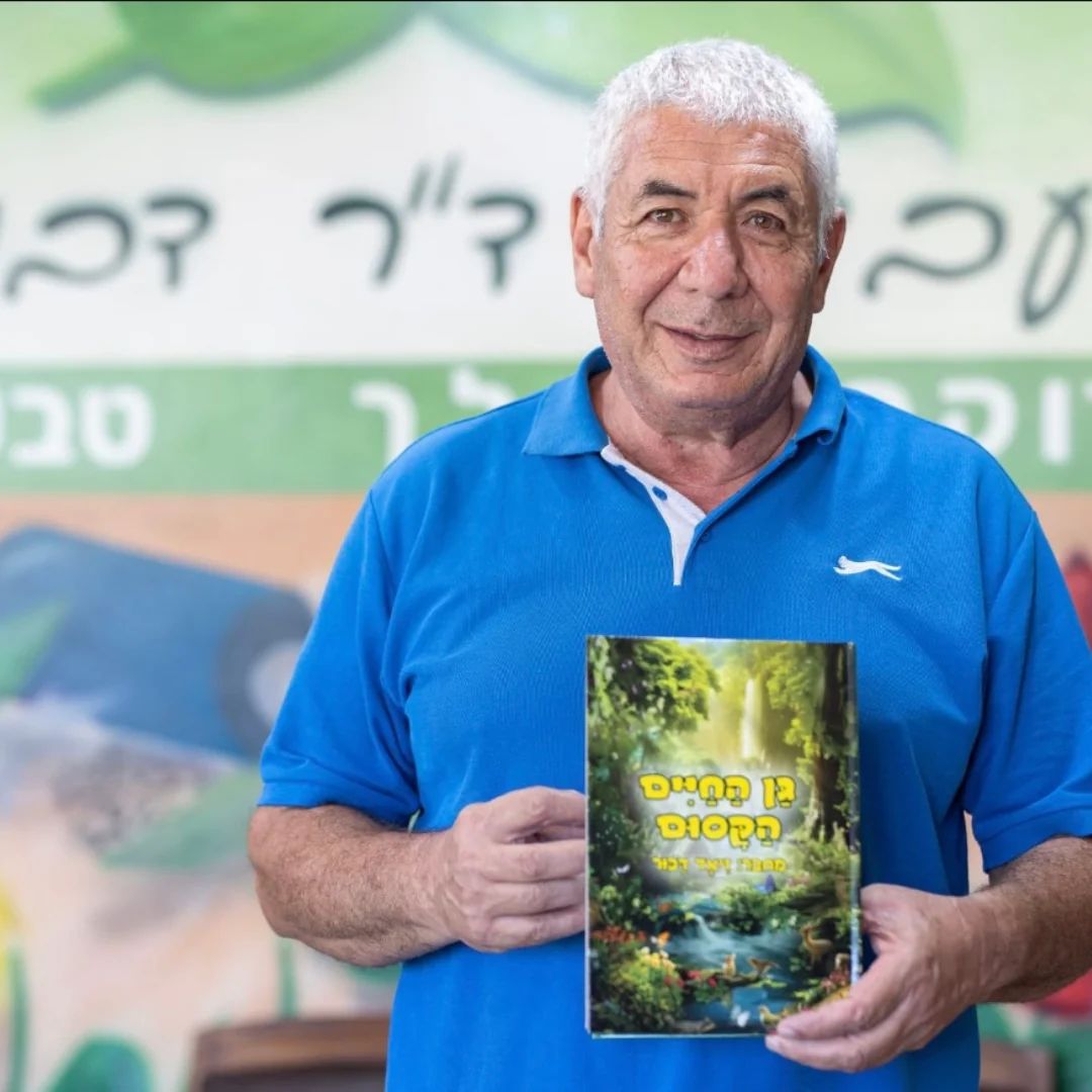 דר דבור מחזיק בספר ״גן החיים הקסום״